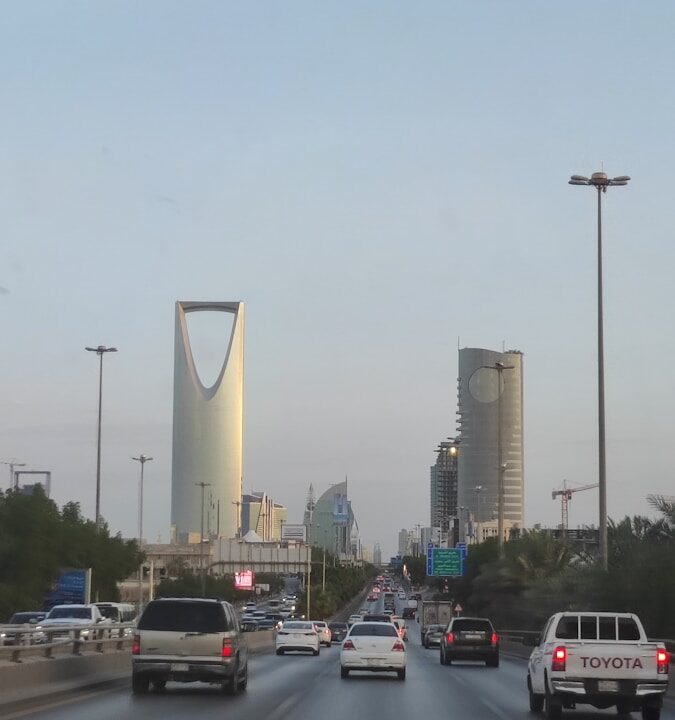 A view of a highway with cars and buildings in the background